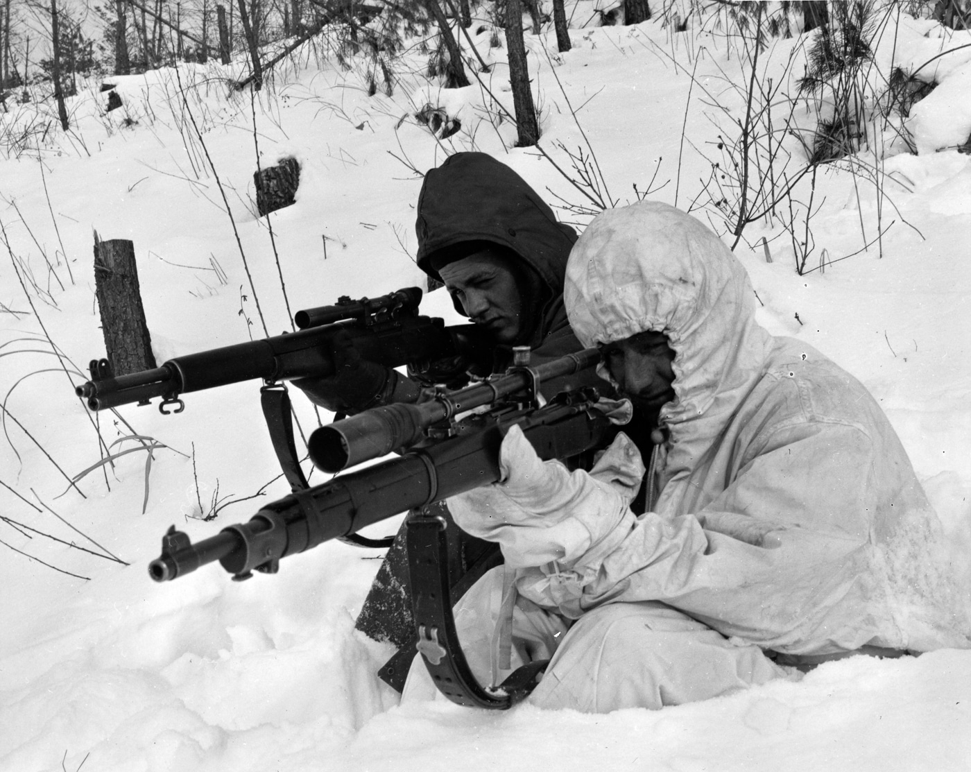 US Marine fires his his M1903A1 and another his M1C sniper rifle