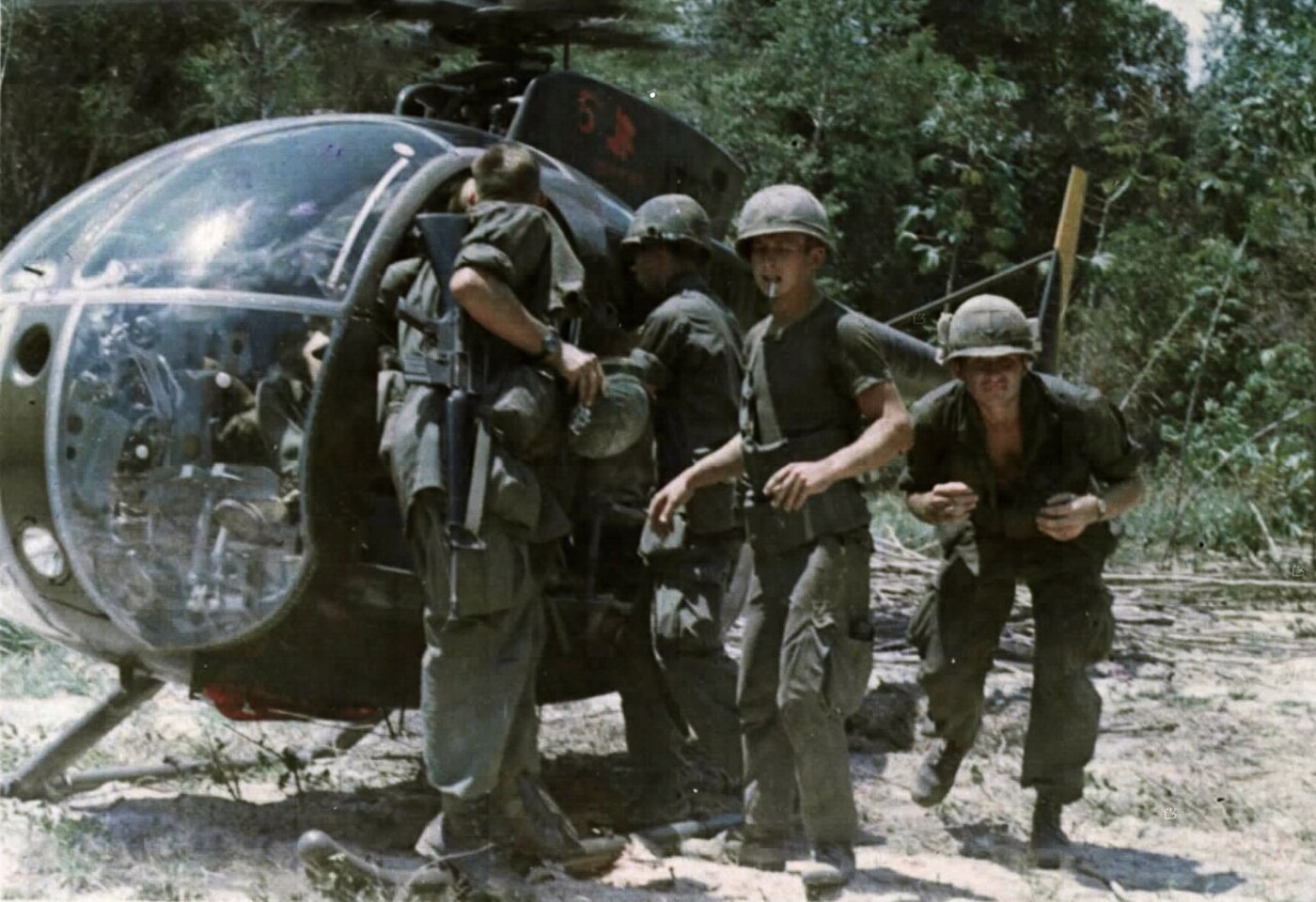 US soldiers load captured intelligence onto an OH-6 during the Vietnam war