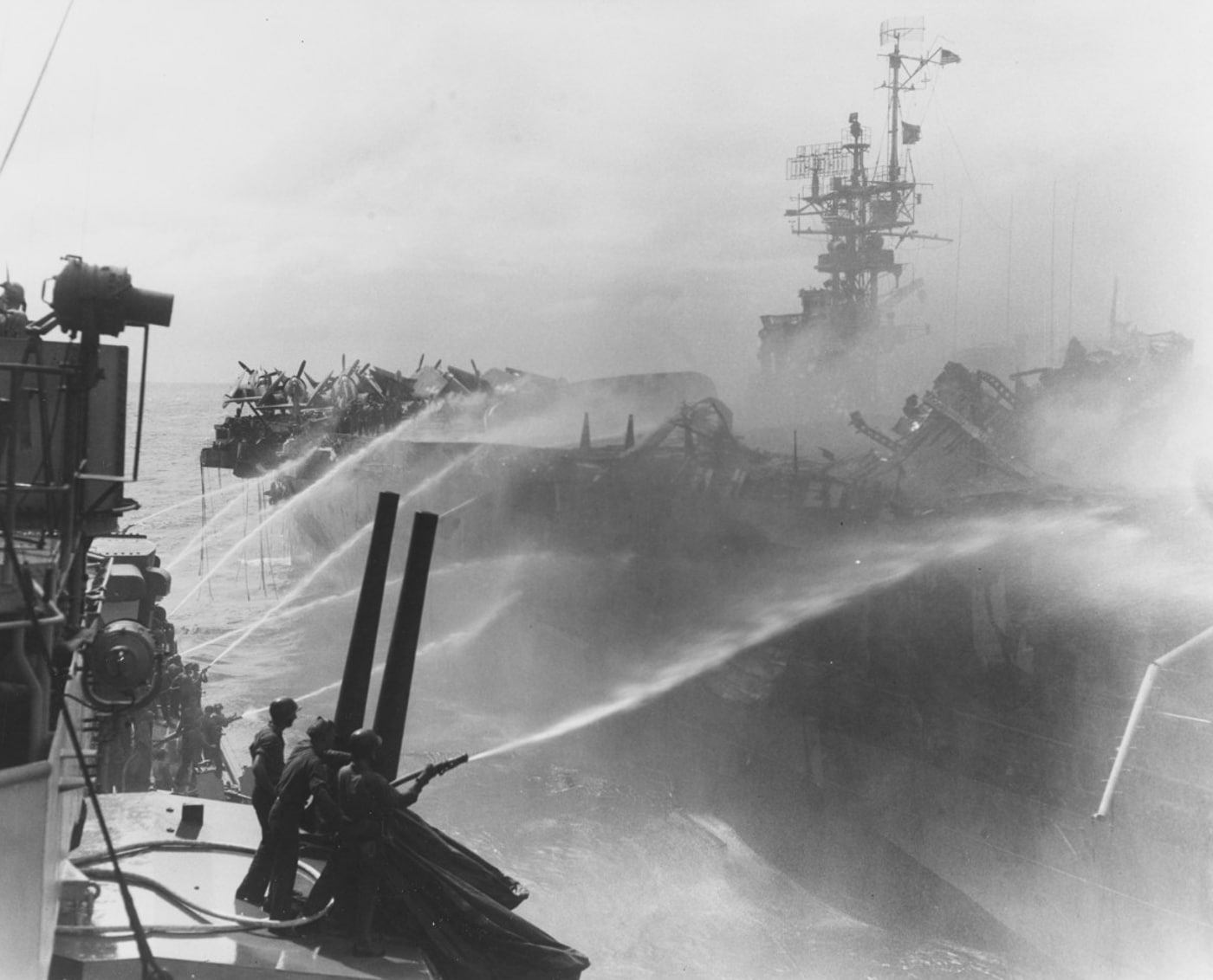 crewmen on USS Birmingham assist with damage control on the burning USS Princeton
