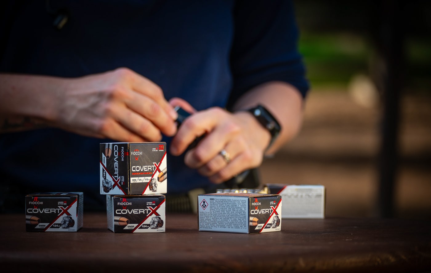 A hand is shown loading Fiocchi CovertX 9mm 124-gr. JHP cartridges into a pistol magazine in preparation for range testing. Two 20-round boxes of the defensive ammunition provided enough rounds for chronograph work, gel penetration testing, accuracy groups, and practical drills. The Fiocchi CovertX 9mm review covered every aspect of real-world carry performance, starting with how the ammunition handled basic magazine loading. Cartridge dimensions and case finish appeared consistent across the entire test lot. Every round chambered, fired, and ejected without issue throughout the session. Reliability is the single most important quality in a defensive handgun load, and CovertX delivered from the first magazine to the last. This self-defense ammunition gave no reason for concern before, during, or after testing.