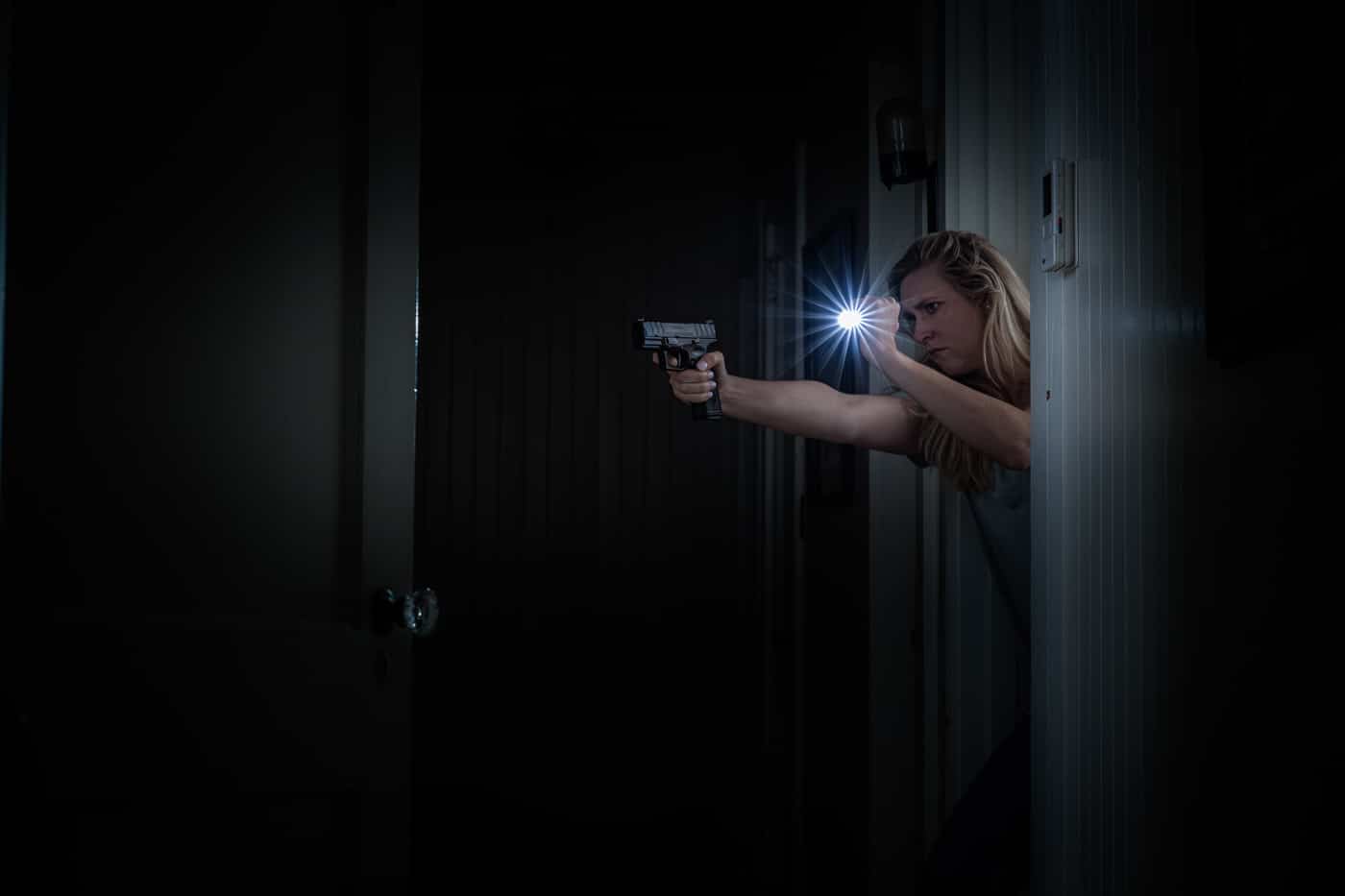 woman with handgun and flashlight