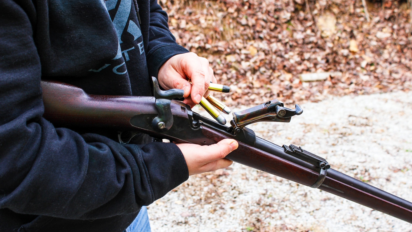 demonstrating how to reload a trapdoor rifle