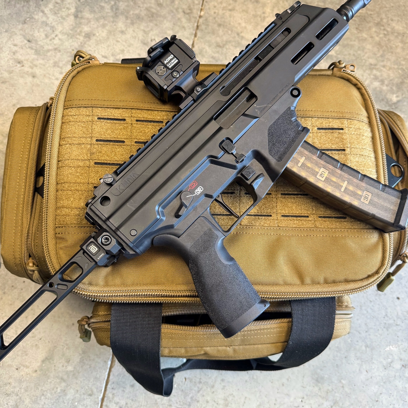 A Savior Specialist Range Bag is shown alongside its contents, photographed for an honest, no-spin review of its performance. This range bag review weighs both the benefits and the tradeoffs after extended real-world testing. On the plus side, the tactical range bag offers excellent organization through pistol sleeves, an adjustable center divider, and a removable magazine panel.