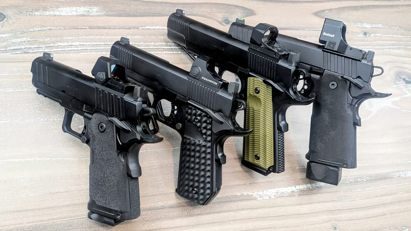 The image shows a row of Springfield Armory 1911-style pistols, including a double-stack Prodigy, with assorted miniature red dot sights installed on their slides. Adding optics to a 1911 simplifies aiming by giving the shooter one bright dot to focus on. These pistol optics help with quicker target acquisition and better hits at longer ranges.