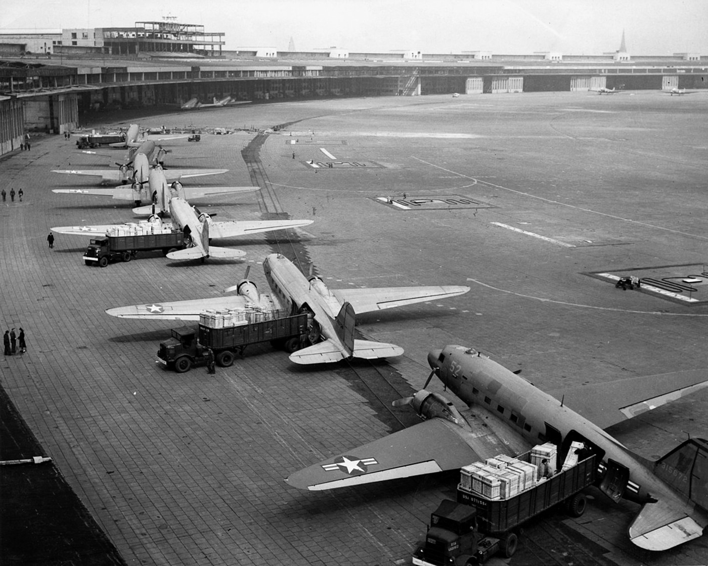 C-47 Skytrain cargo planes unload food and other goods at Tempelhof Airport during Berlin Airlift
