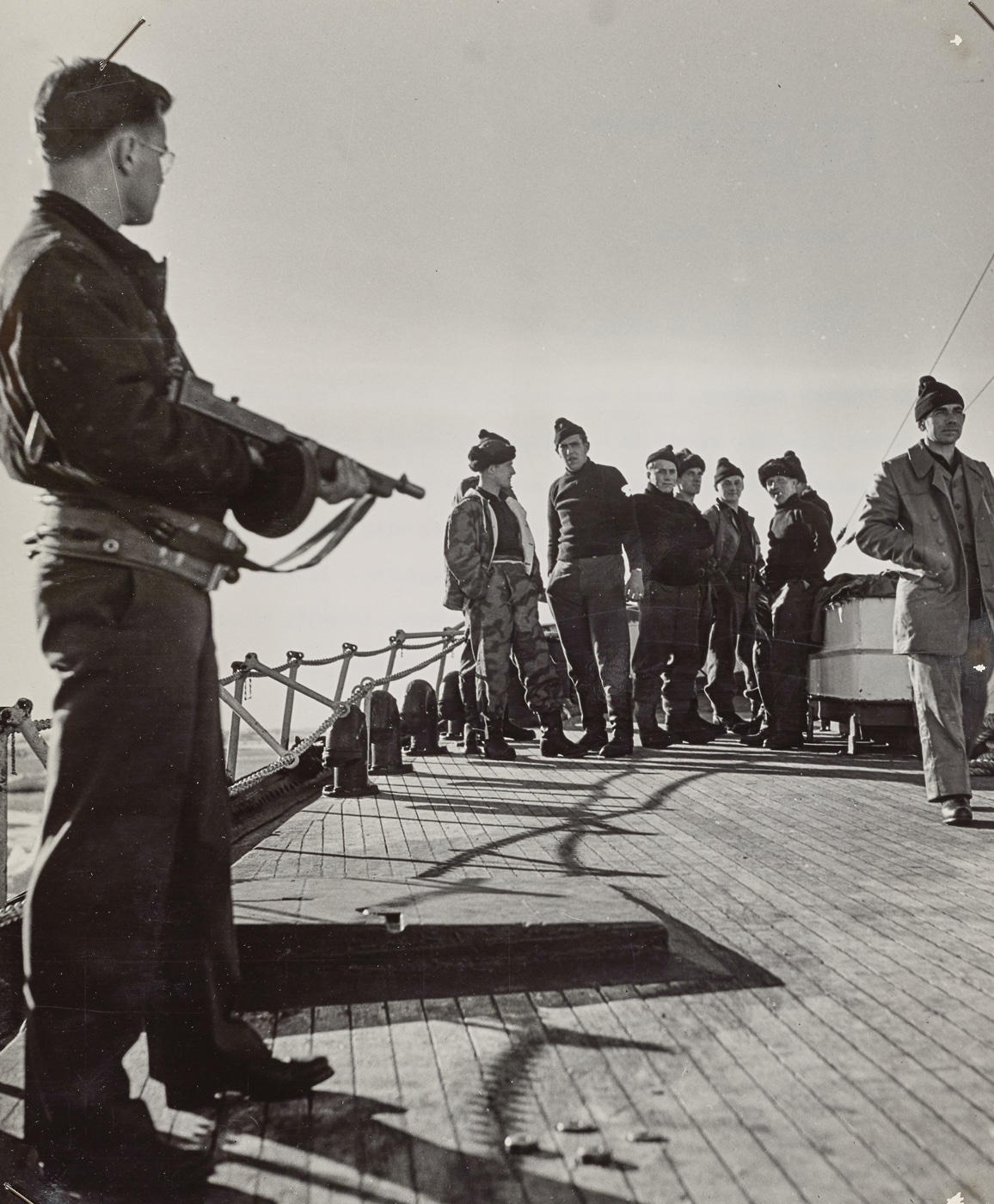 US Coast Guardsman with Thompson submachine gun guards German prisoners captured near Greenland