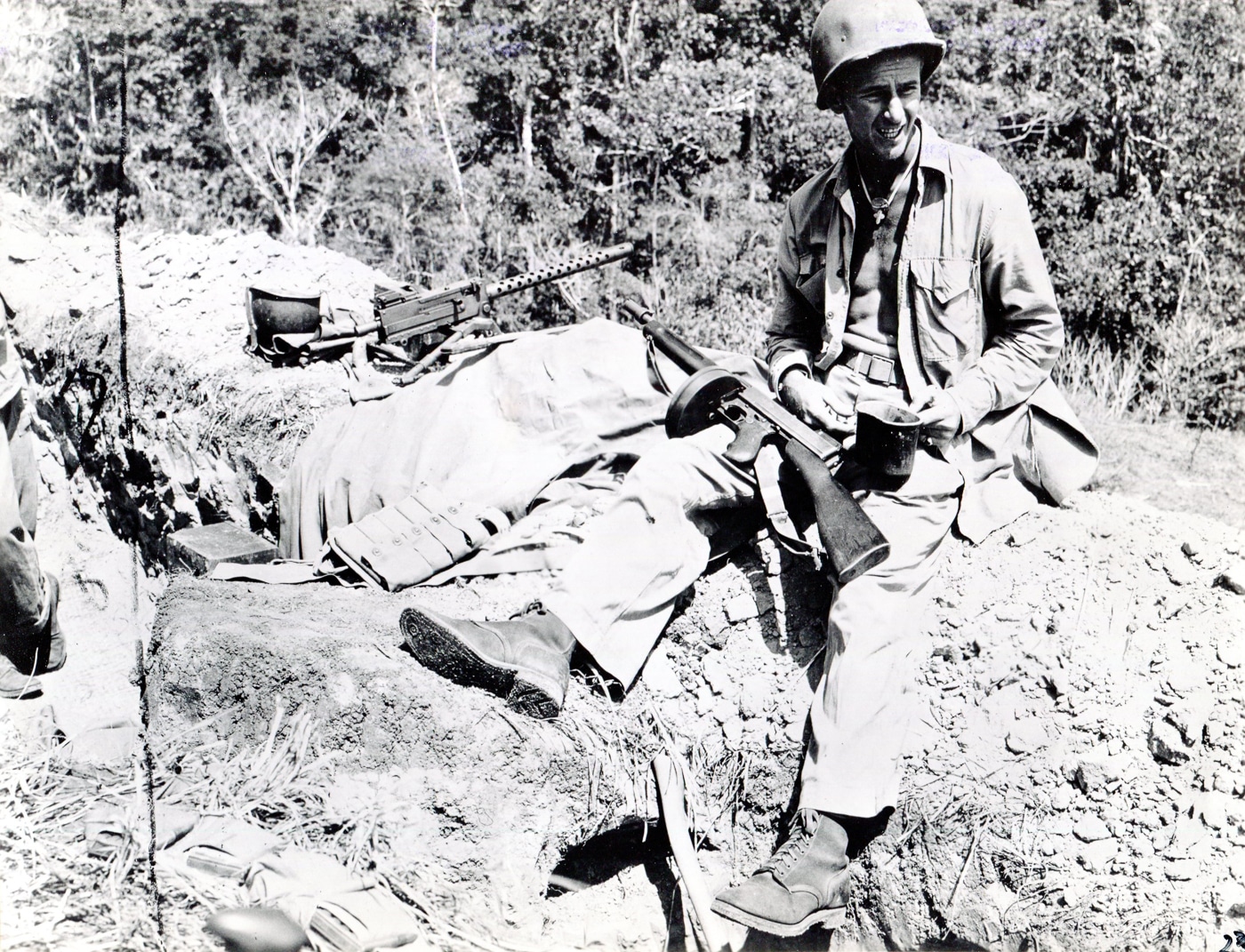 US Marine armed with a Thompson SMG eats chow near a M1919 Browning machine gun position