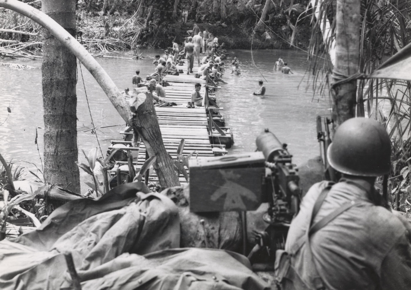 US Marine with M1917 Browning machine gun watches over Marines bathing in Mantanika River on Guadalcanal