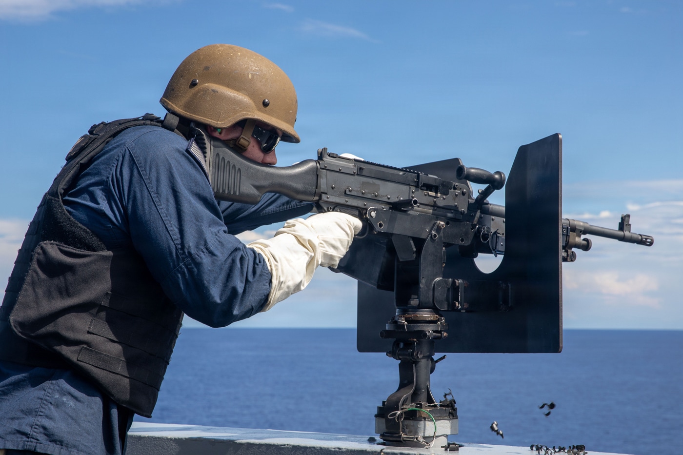 US Navy sailor fires an M240 aboard the USS Fort Lauderdale