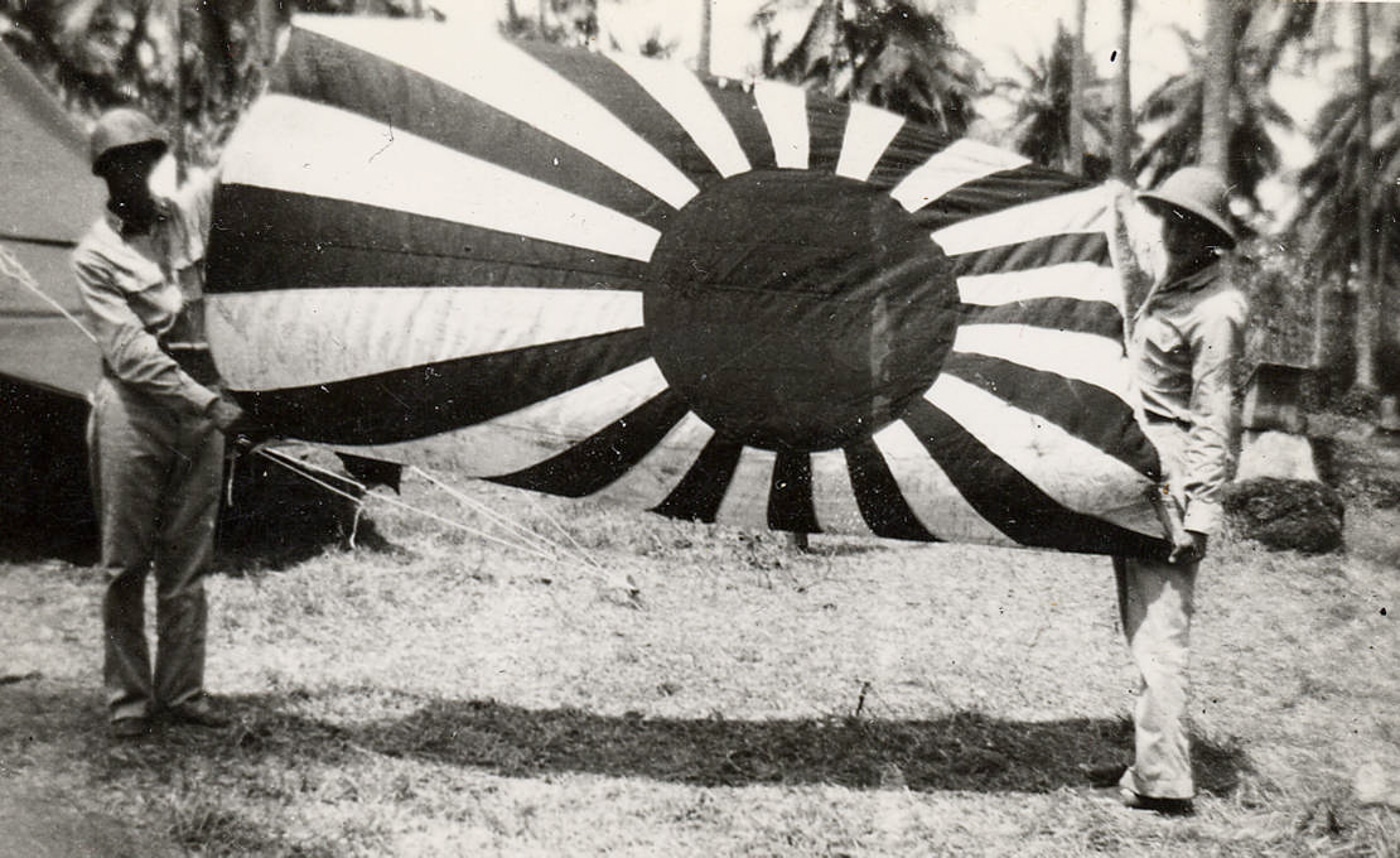 US soldiers hold Japanese flag captured during the Guadalcanal Campaign