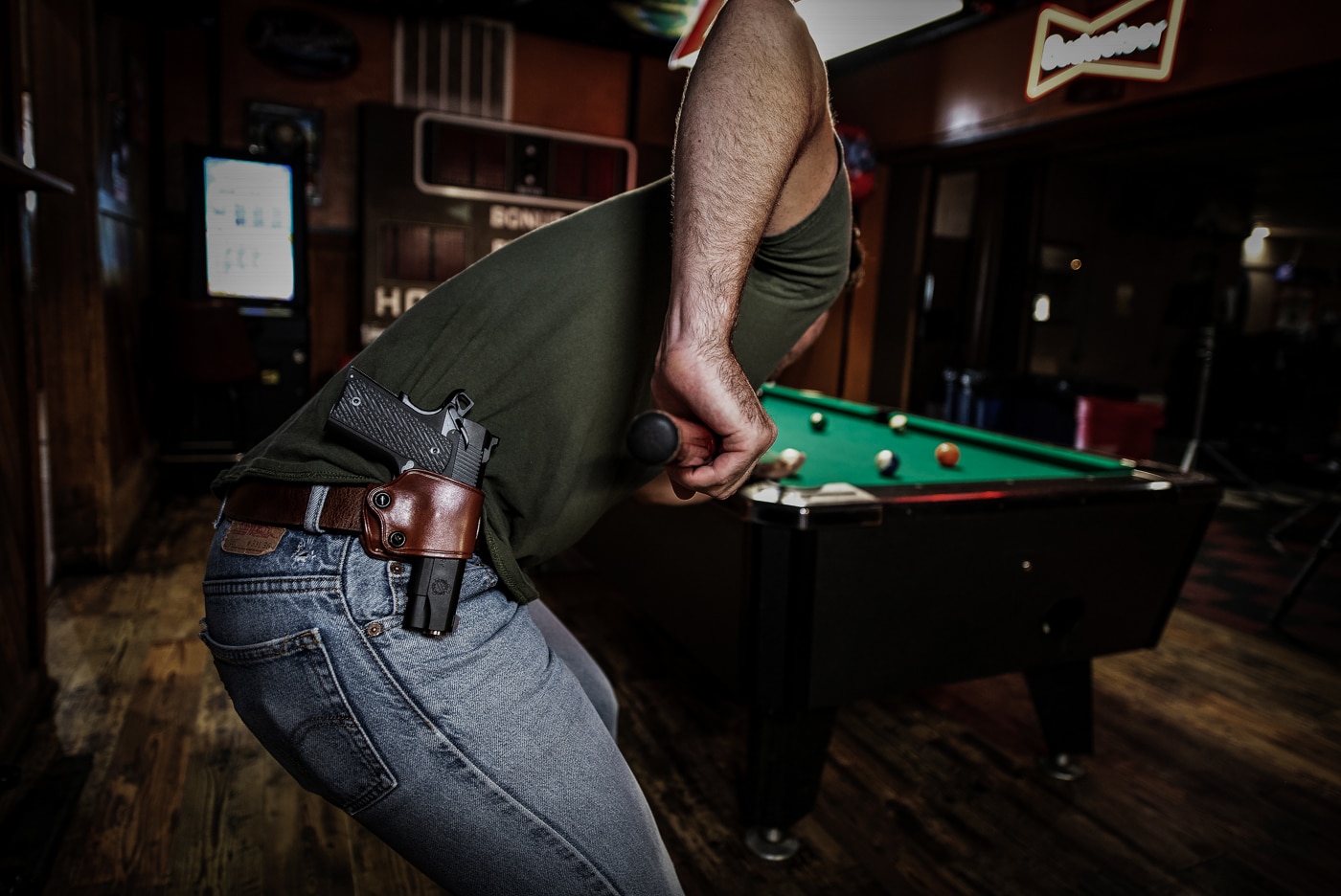 man open carries a 1911 pistol while playing billiards