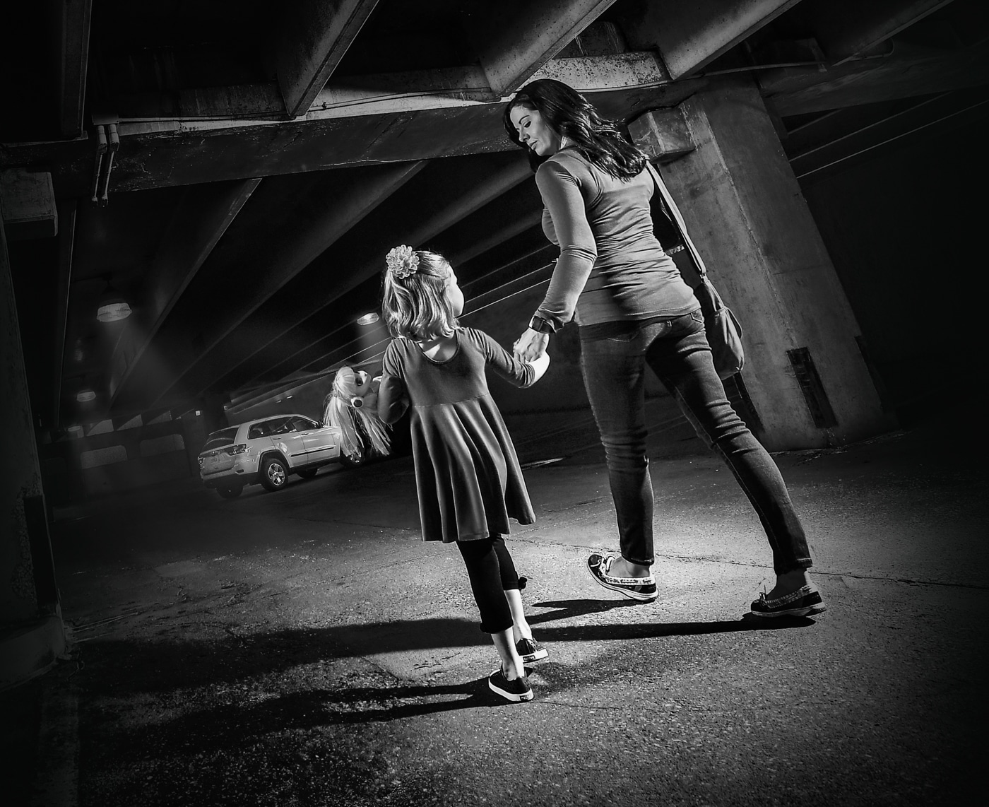 mom walking with daughter in parking garage at night