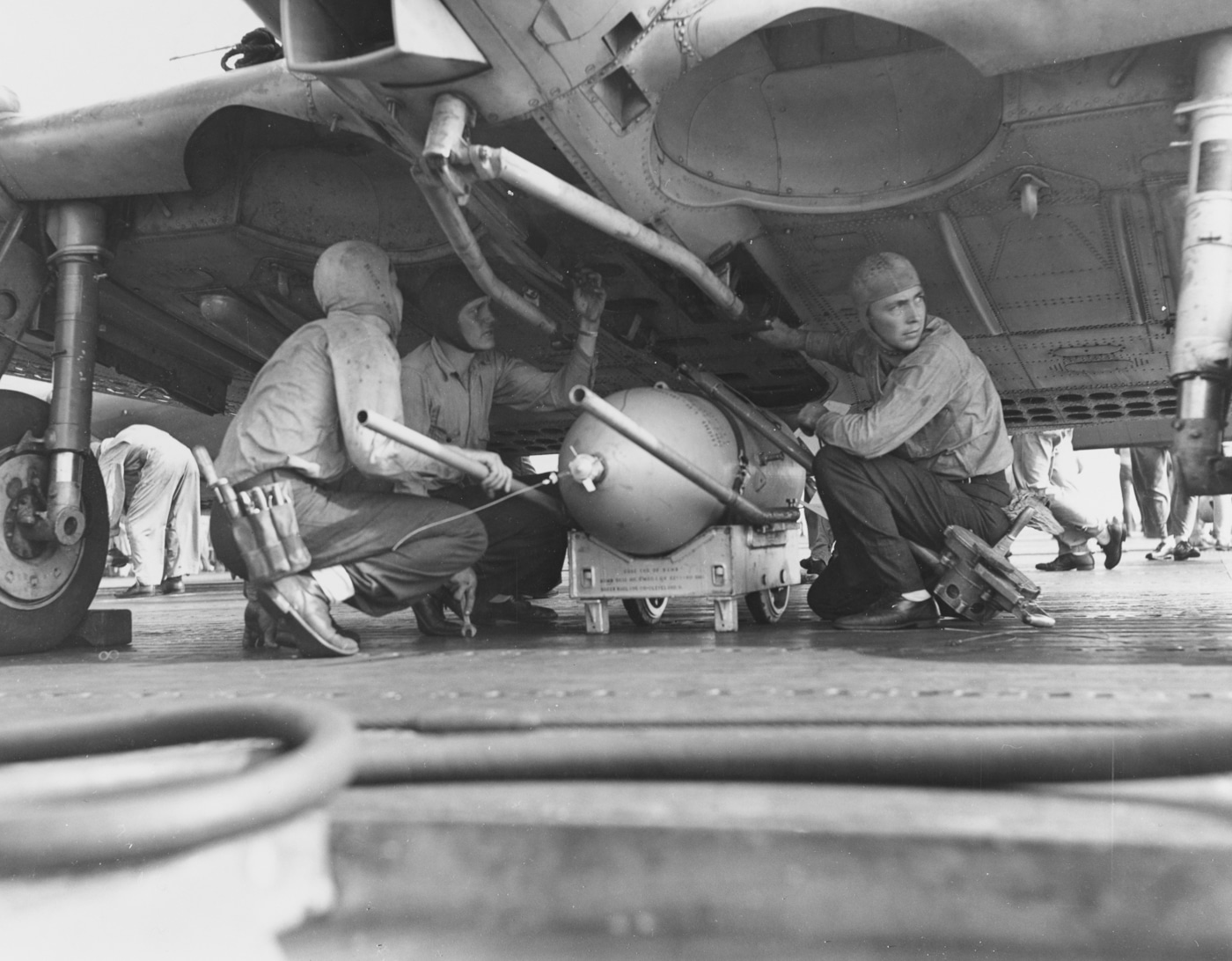 ordnancemen of Scouting Squadron Six VS-6 load a 500 pound demolition bomb on an SBD scout bomber on the flight deck of USS Enterprise CV-6 during the first day of strikes on Guadalcanal