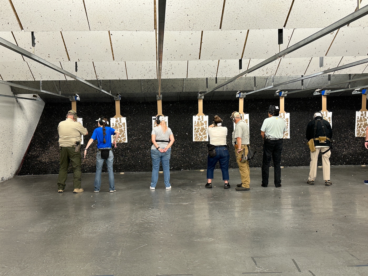 students learning how to shoot handguns receive instruction at an indoor shooting range