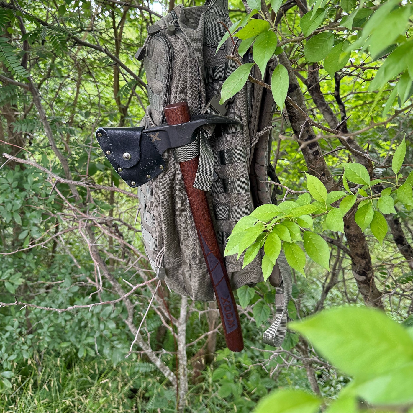 survival axe needs to be easy to transport as seen here attached to a backpack using the MOLLE system