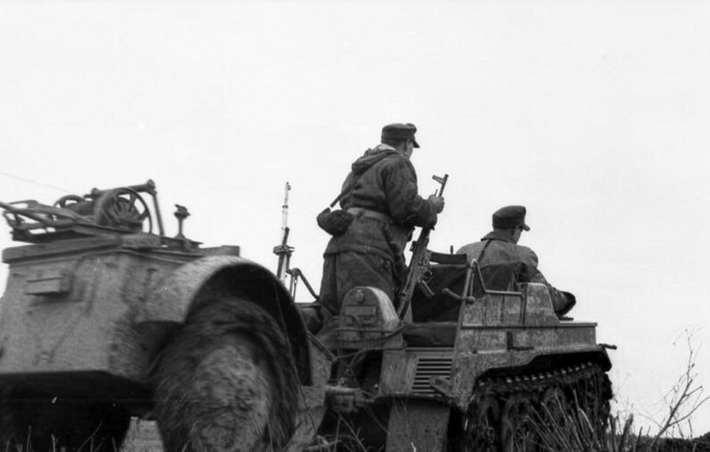 German soldier with StG44 assault rifle rides in the back of a Kettenkrad