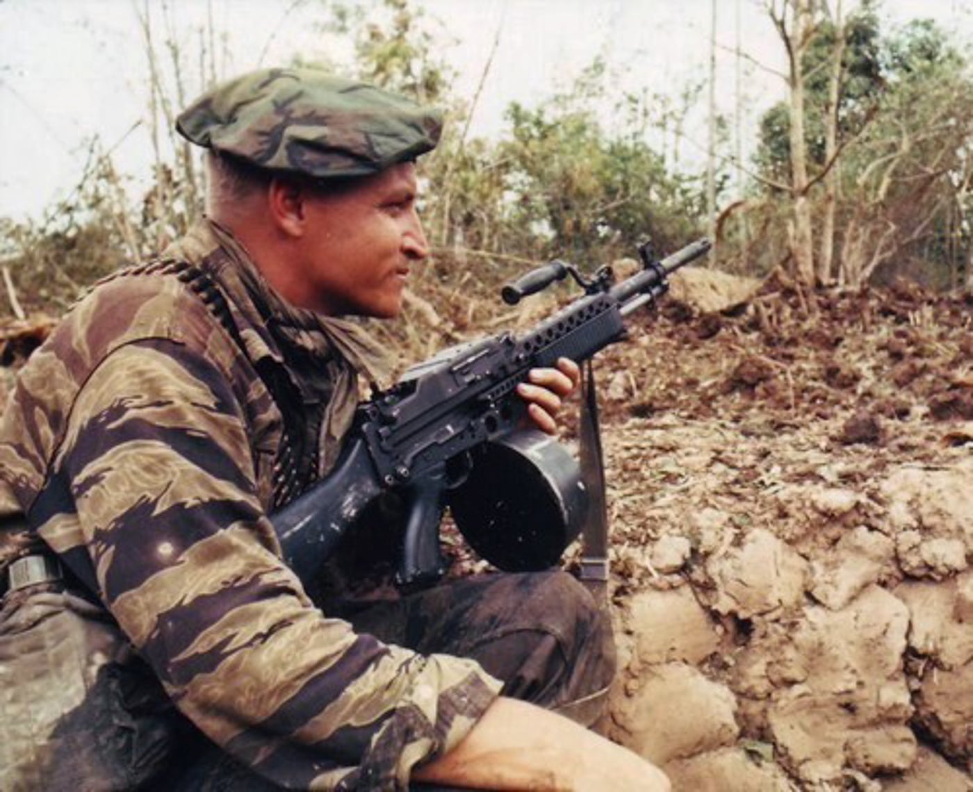US Navy SEAL in Tiger Stripe camouflage uniform armed with a Stoner 63 machine gun in Vietnam