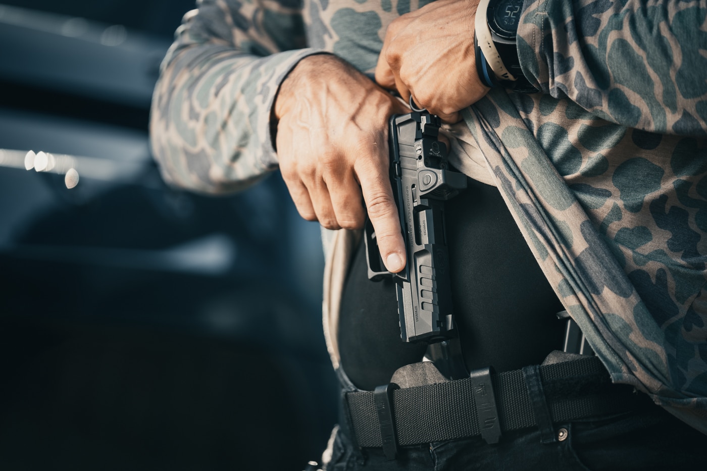 man draws a Springfield Armory pistol from a holster to respond to an immediate life threatening attack
