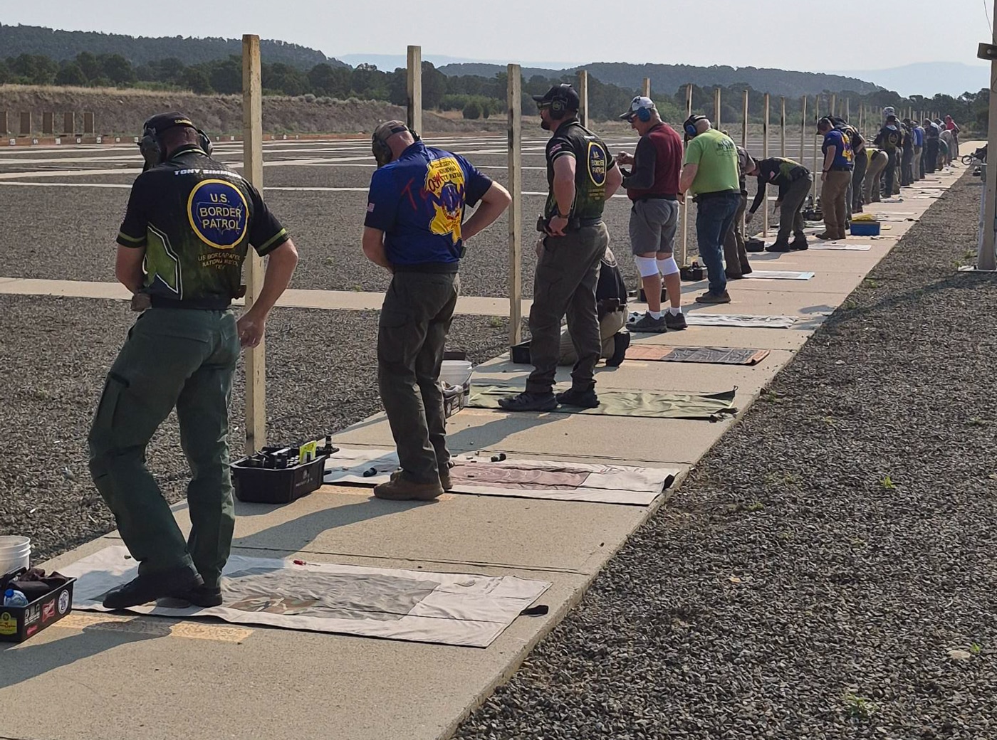 people lined up on shooting line preparing to shoot a string of fire