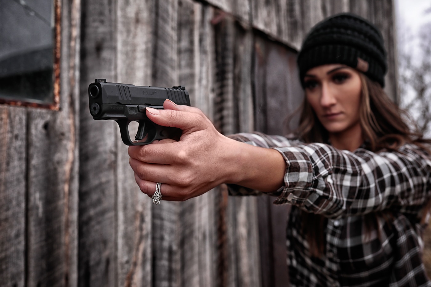 woman aims a Springfield Armory handgun in a defensive training scenario
